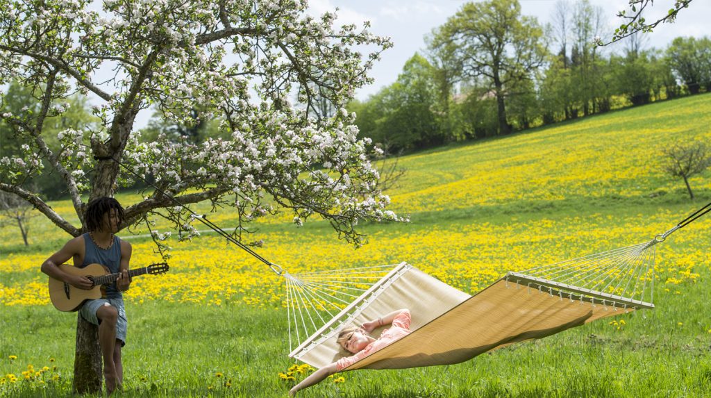 Hier ist eine Hängematten im Freien zu sehen, die an einem Baum aufgehängt wurde